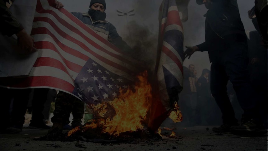 Men burn US and British flags in the street.