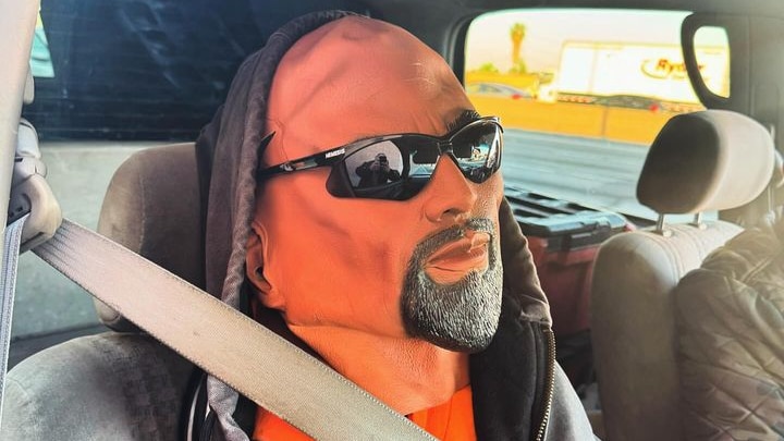 A mannequin wearing a seatbelt, sunglasses and a hoodie. 