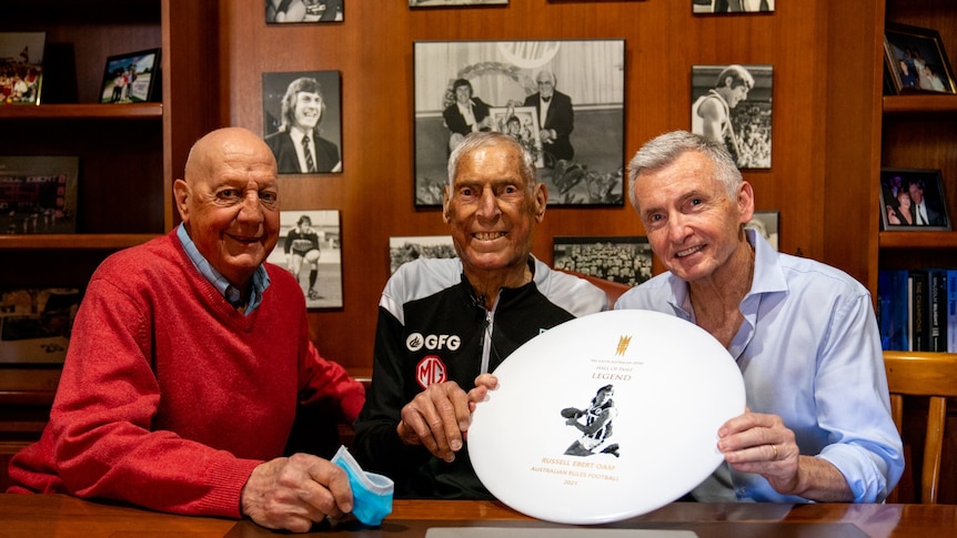 Russell Ebert sits between former SANFL player Barrie Robran (left) and sports presenter Bruce McAvaney (right).