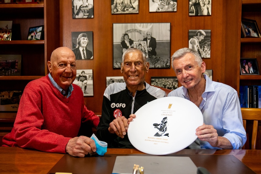 Russell Ebert sits between former SANFL player Barrie Robran (left) and sports presenter Bruce McAvaney (right).