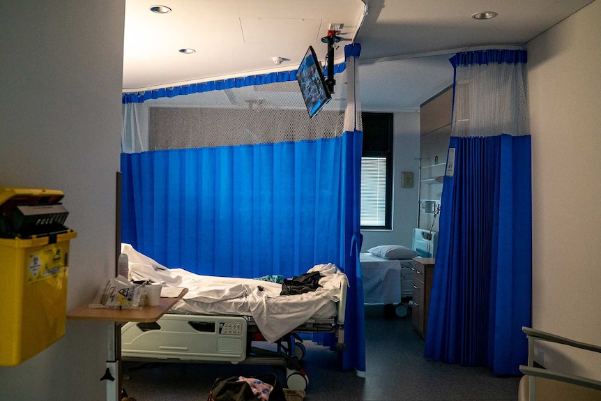 A hospital bed in the Gorman unit of St Vincent's hospital, there is a blue curtain surrounding a bed.