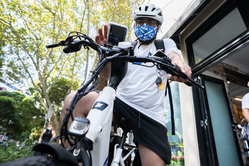 a man on a bike with grocery bag 