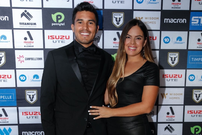 Ulises Davila and wife Lily Davila (right) pose for a photo in cocktail dress.