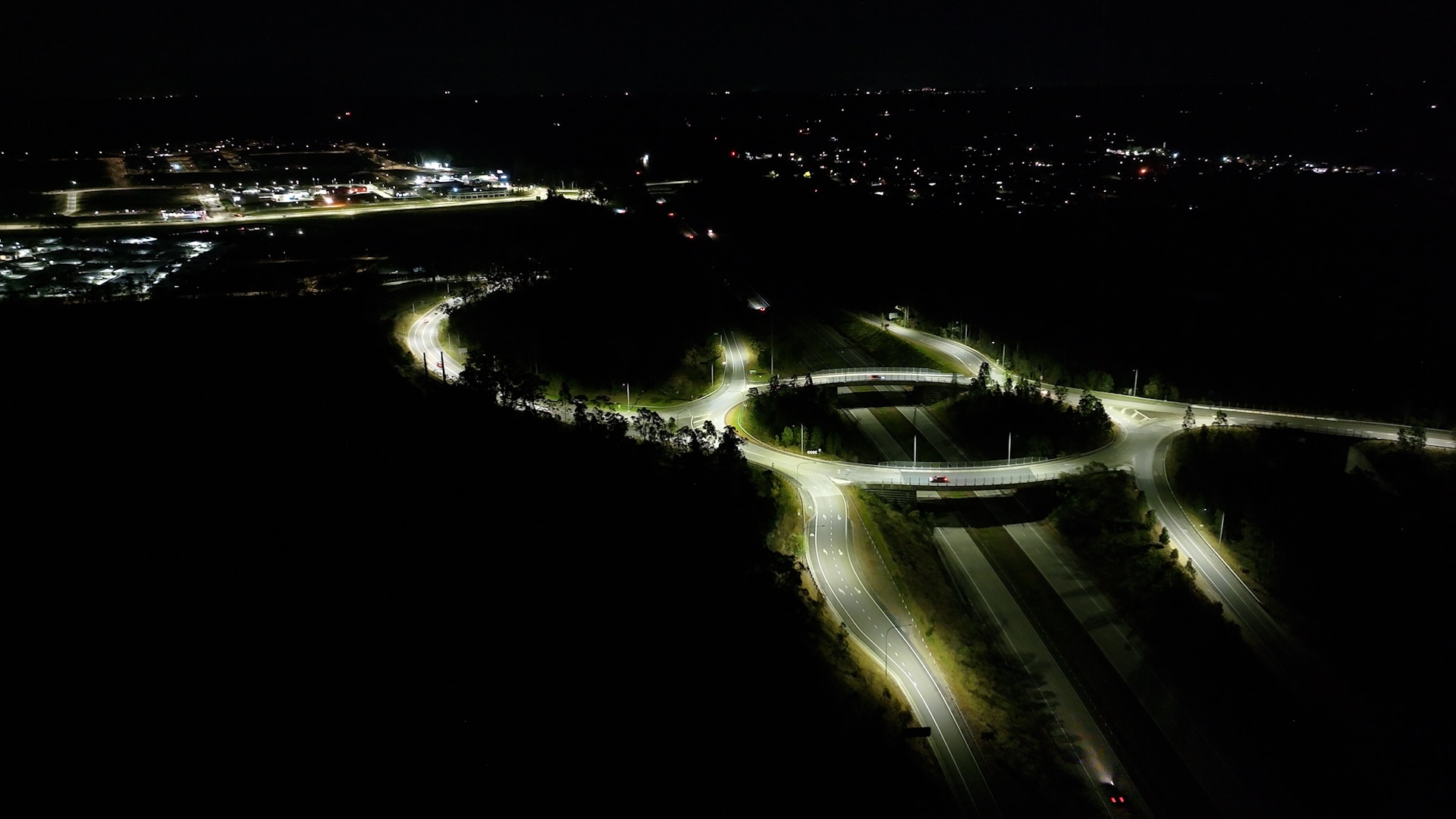 View from above of roundabout lit up with street lighting on an otherwise dark evening. 