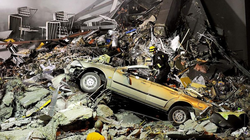 Rescue workers search through the collapsed CTV building after an earthquake in Christchurch.