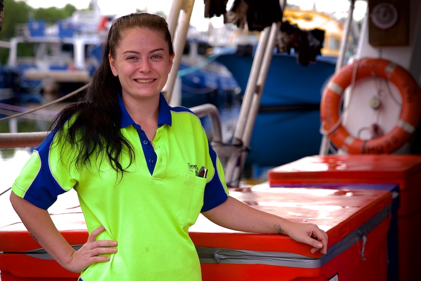 Photo of a young woman next to a boat.