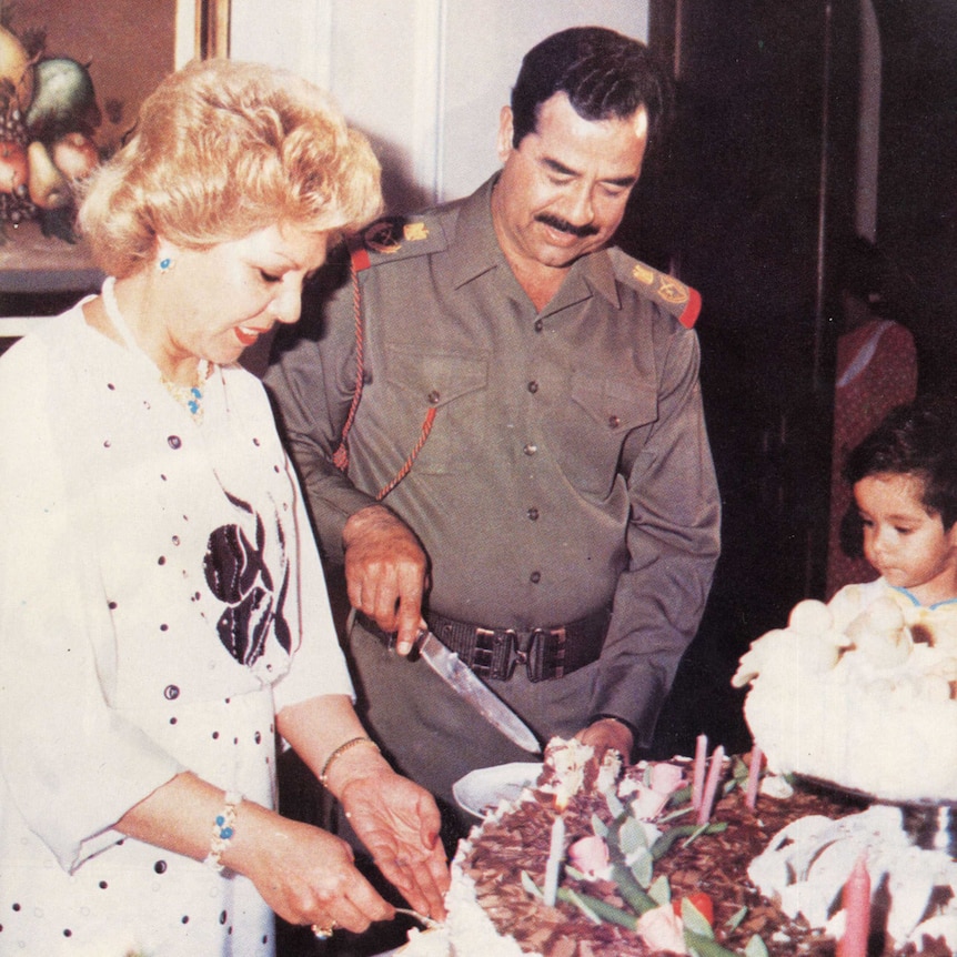 Saddam Hussein cuts into a cake with his first wife Sajida by his side.