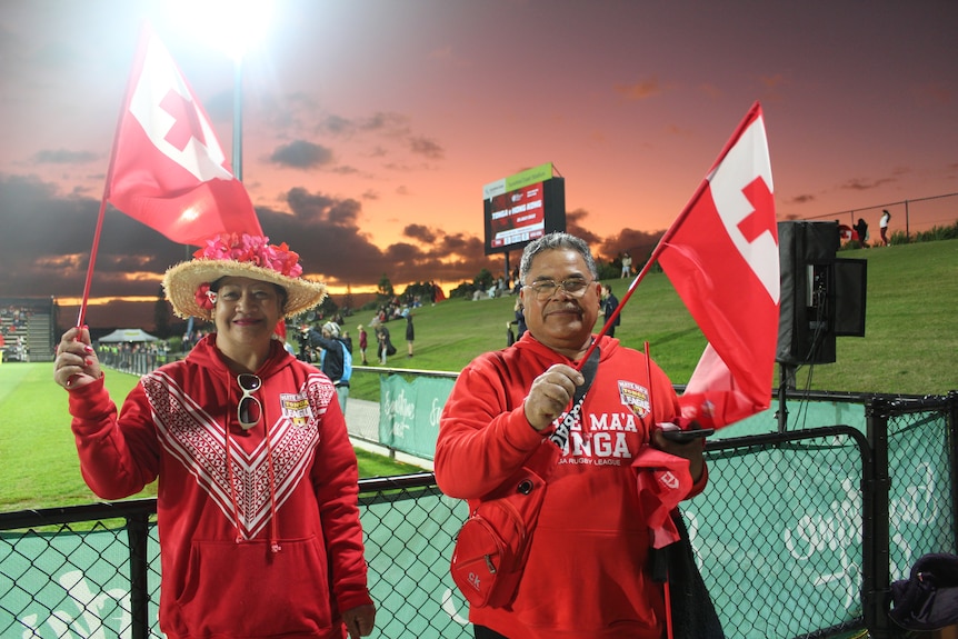 Deux fans tongans agitent des drapeaux lors du match de rugby Tonga vs Hong Kong au Sunshine Coast Stadium.