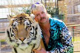 Joe Exotic poses for a photo with a tiger