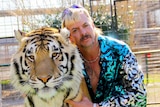 Joe Exotic poses for a photo with a tiger