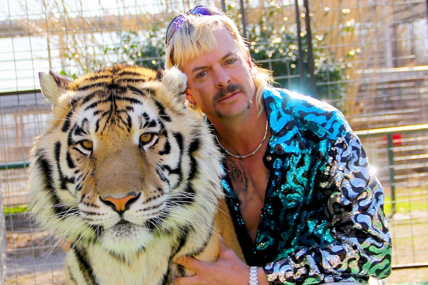 Joe Exotic poses for a photo with a tiger