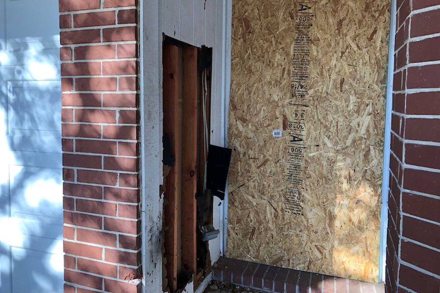 This is the boarded-up doorway of the home that was hit with a parcel bomb on March 2.