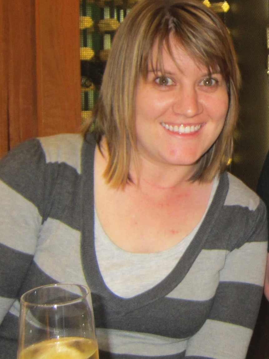 Kirby Littley wearing a striped top, holding a glass of white wine.