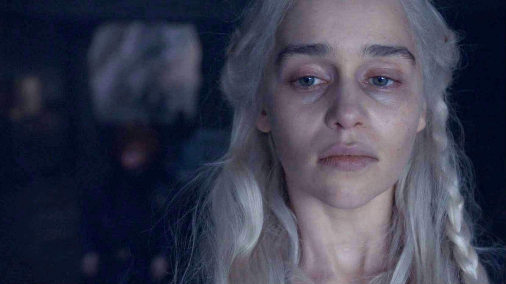 A haunted-looking Daenerys with dark circles under her eyes looks out the window.