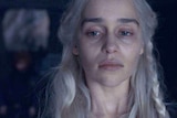 A haunted-looking Daenerys with dark circles under her eyes looks out the window.