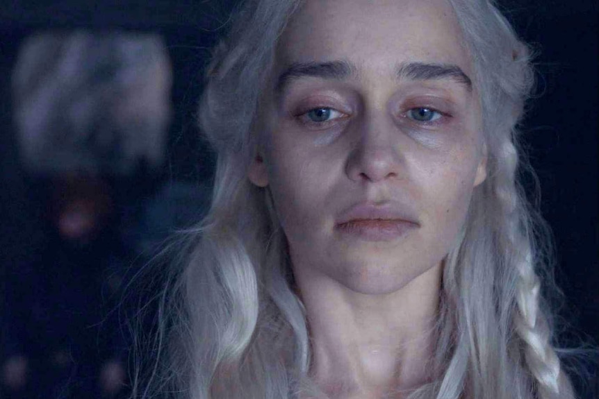 A haunted-looking Daenerys with dark circles under her eyes looks out the window.