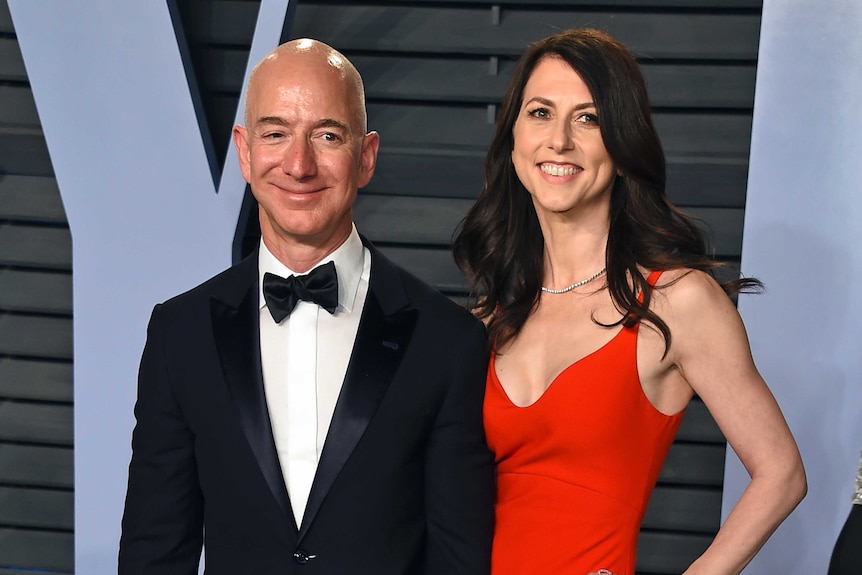 Jeff Bezos con traje negro y pajarita, MacKenzie Bezos usa un vestido de noche rojo.