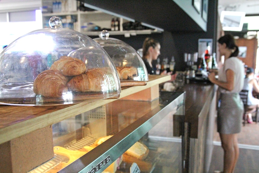 Un croissant sur le comptoir d'un café de la Gold Coast avec un client