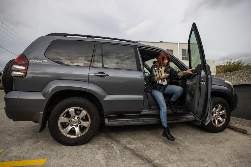 A woman getting out of her car.