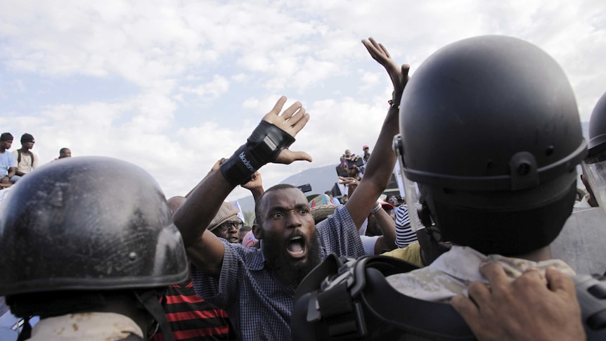 Protester argues with National Police officers at a police cordon during a demonstration by opposition groups in Port-au-Prince.