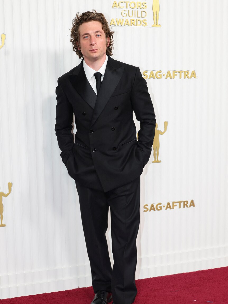 Jeremy Allen White in a black suit on the red carpet. 