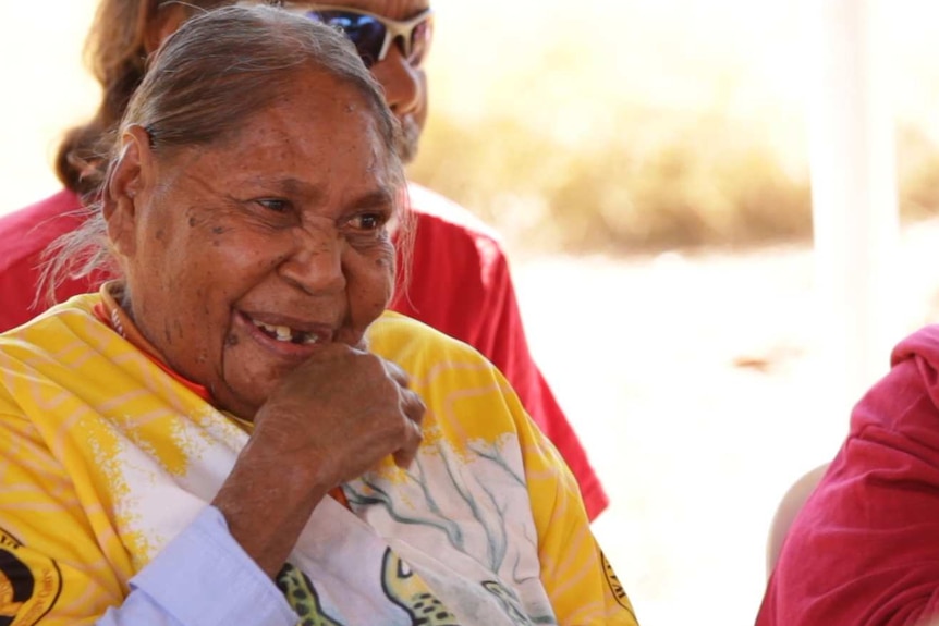 Two Indigenous women in the foreground watching a performance.