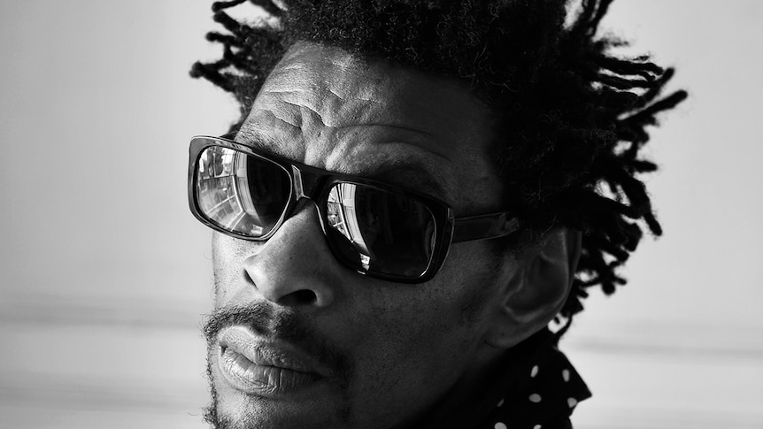 Very close up black and white photo of Daddy G from Massive Attack wearing sunglasses