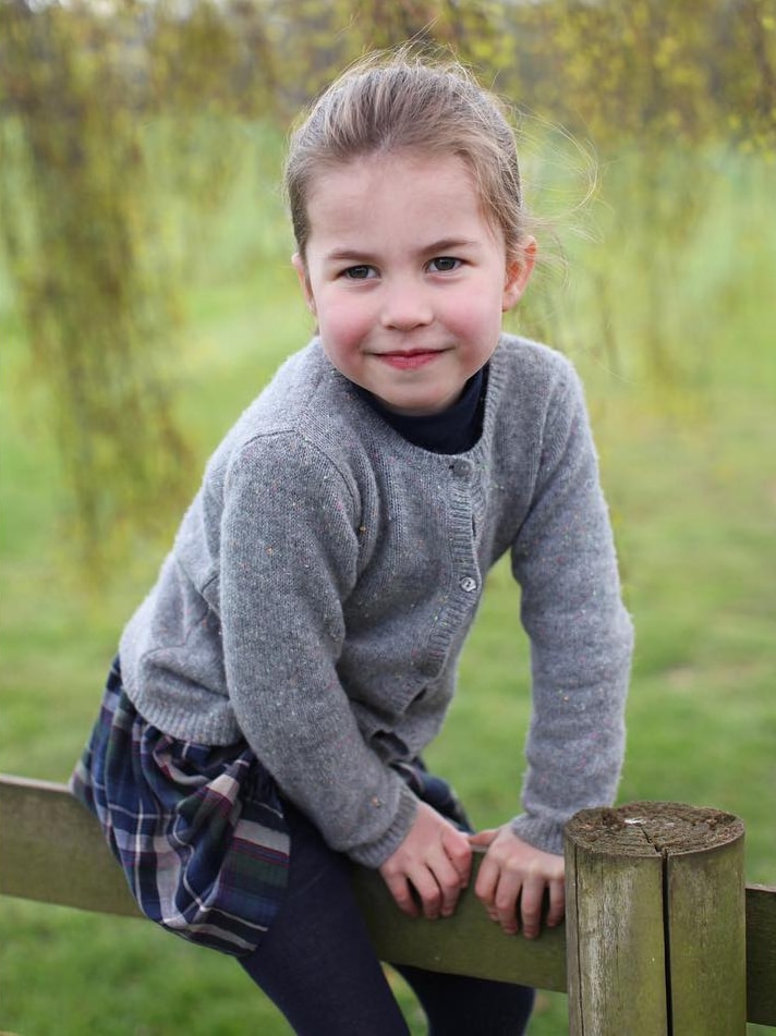 Princess Charlotte sits on a fence