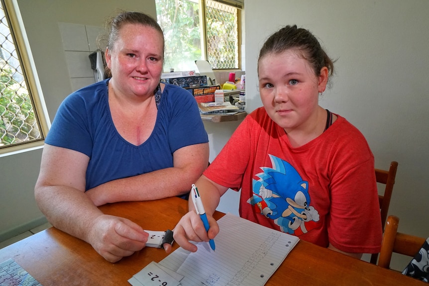 Jennifer Stewart and her daughter Sophie-Lea Cooke sit at a table as Jennifer helps with home schooling.