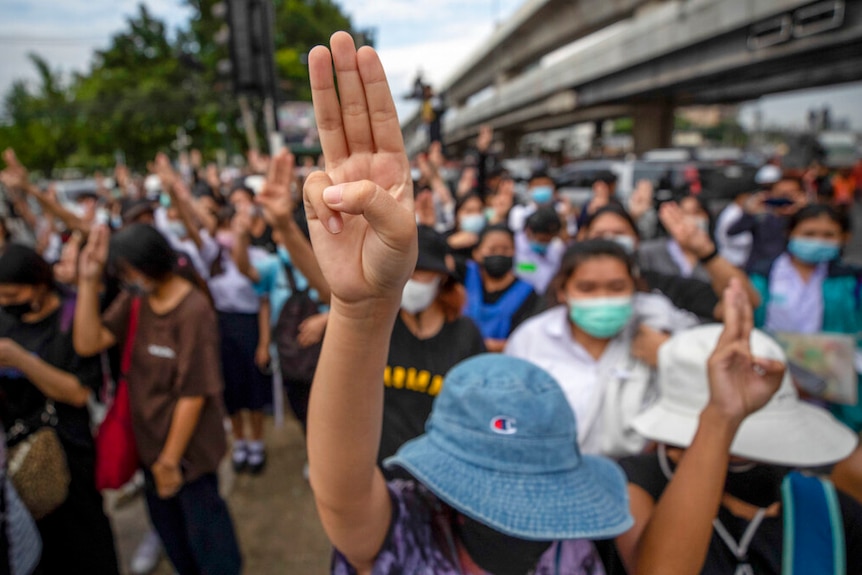 Des militants pro-démocratie lancent un salut à trois doigts lors d'une manifestation à l'intersection de Kaset, dans la banlieue de Bangkok.