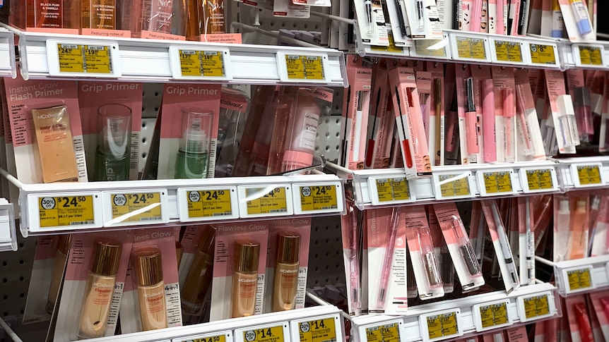 Rows of light pink and white packaged cosmetic products in a supermarket.
