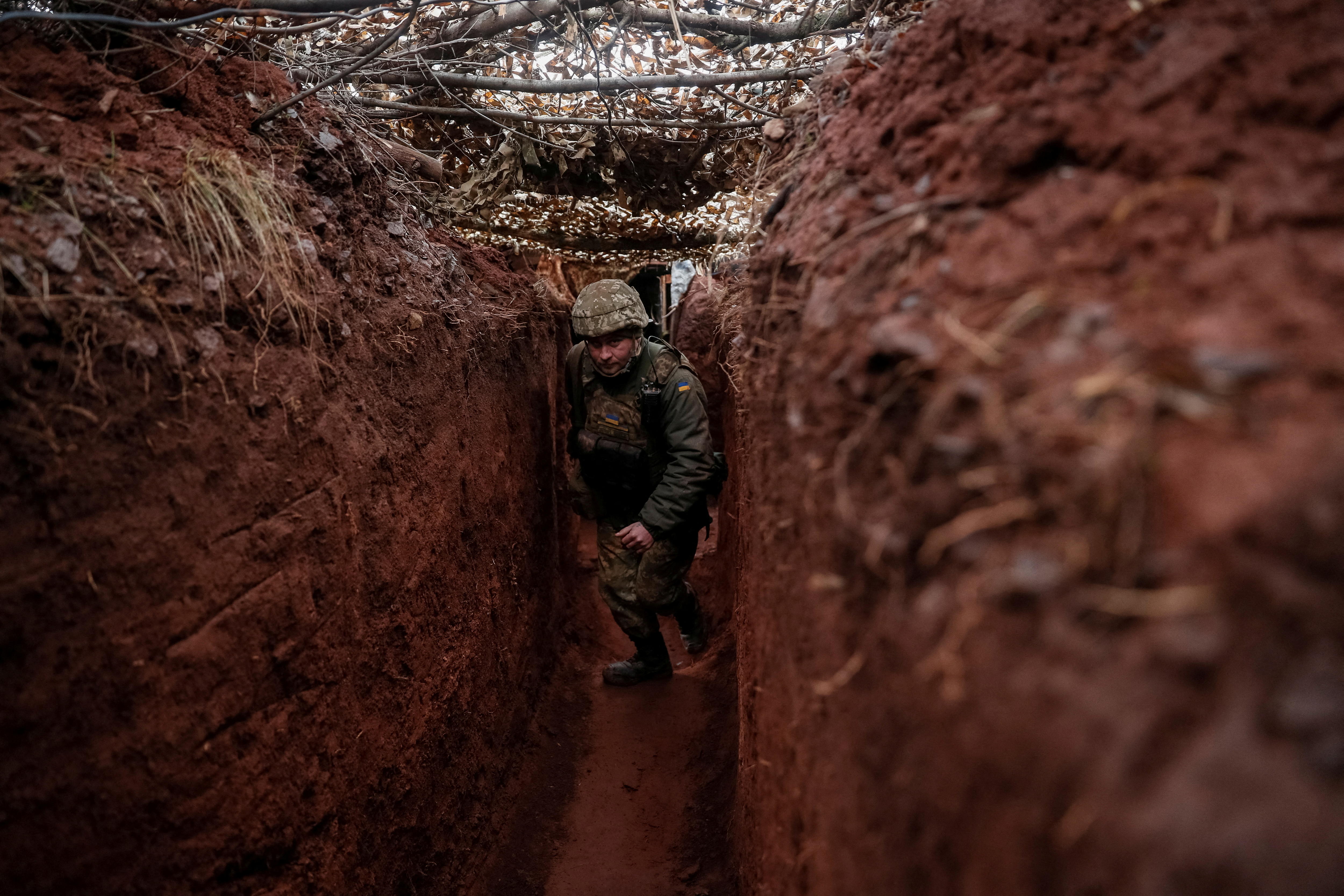 A soldier walks along a trench.