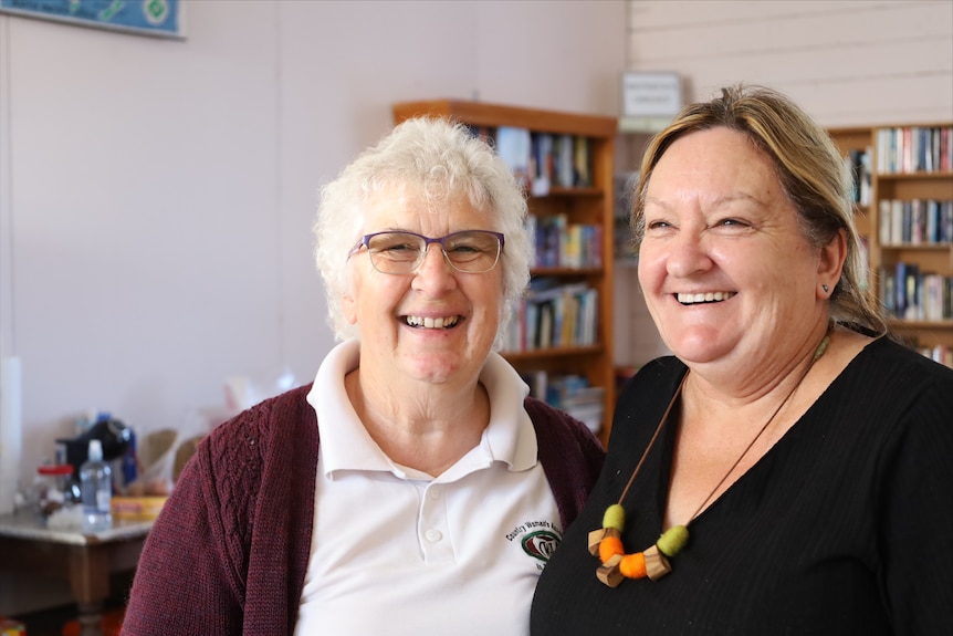  A woman with silver hair and a younger woman smiling