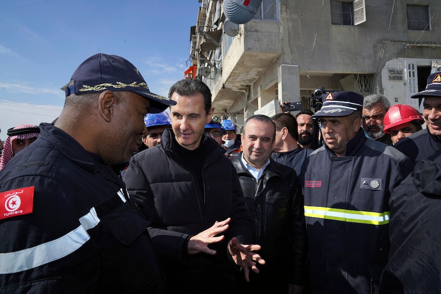 Syrian president (second left) speaks with rescue workers at earthquake affected area.