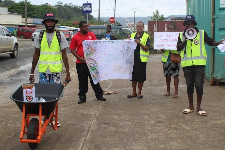Volunteers from Red Cross Vanuatu push wheelbarrows to raise funds for Australian bushfire victims.