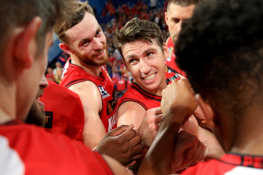 Perth Wildcats players in a team huddle.