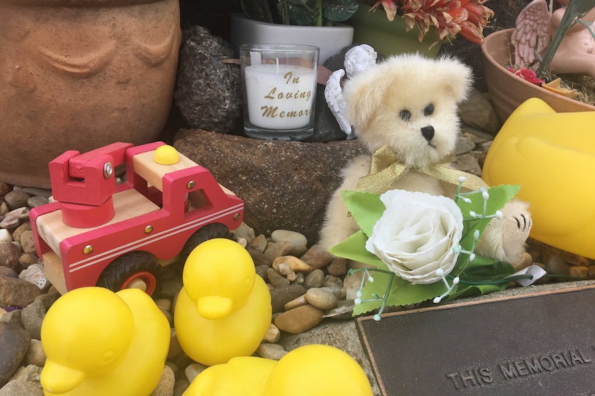 Toys and candles at grave.