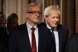 Boris Johnson stands behind opposition Labour Party Leader Jeremy Corbyn.