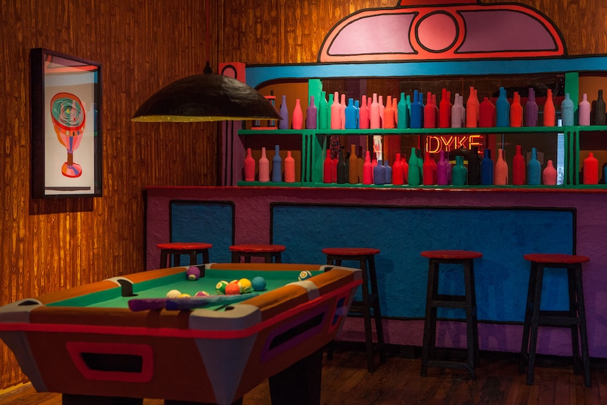 Pool room in a 70s-style lesbian bar, made from brightly coloured cardboard and wood.