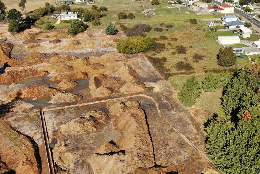 Aerial view of a large area of soil and water on the outskirts of a town