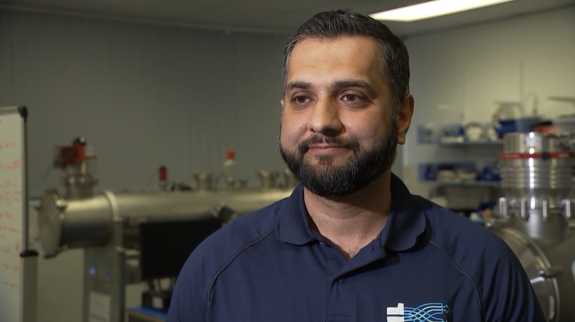 Un hombre frente a equipos científicos de alta tecnología.