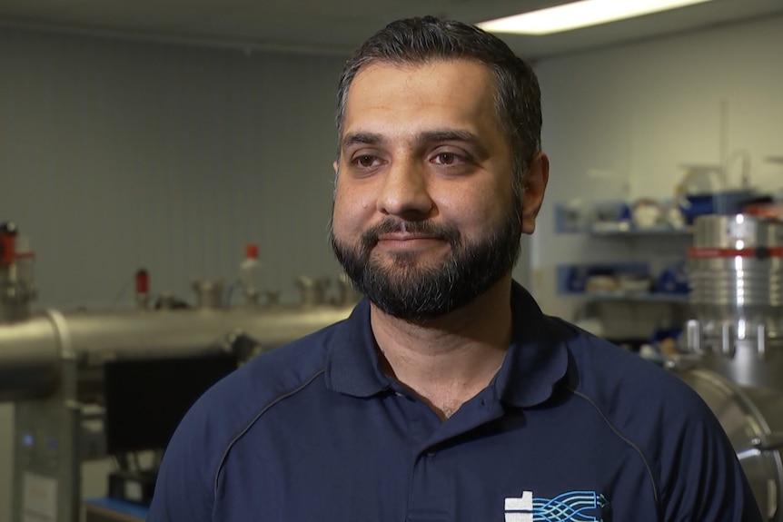 A man in front of high-tech scientific equipment.