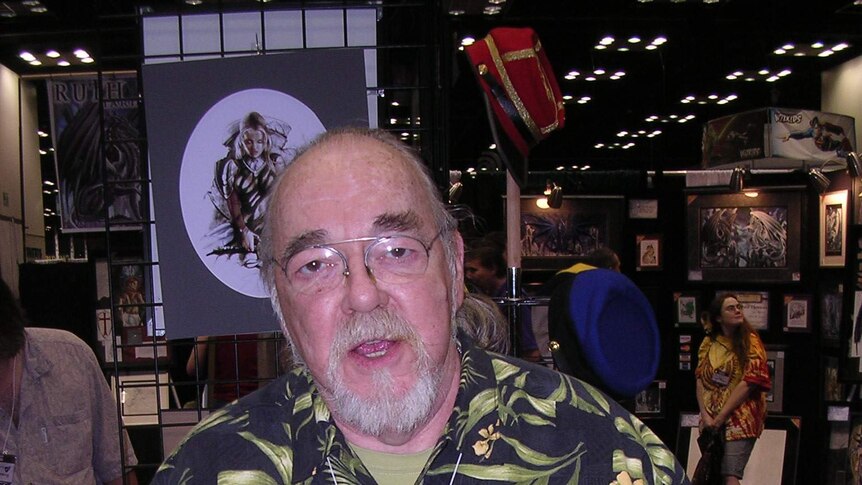 A large bespectacled man in his 50s wears a bright Hawaiian shirt at a gaming convention.