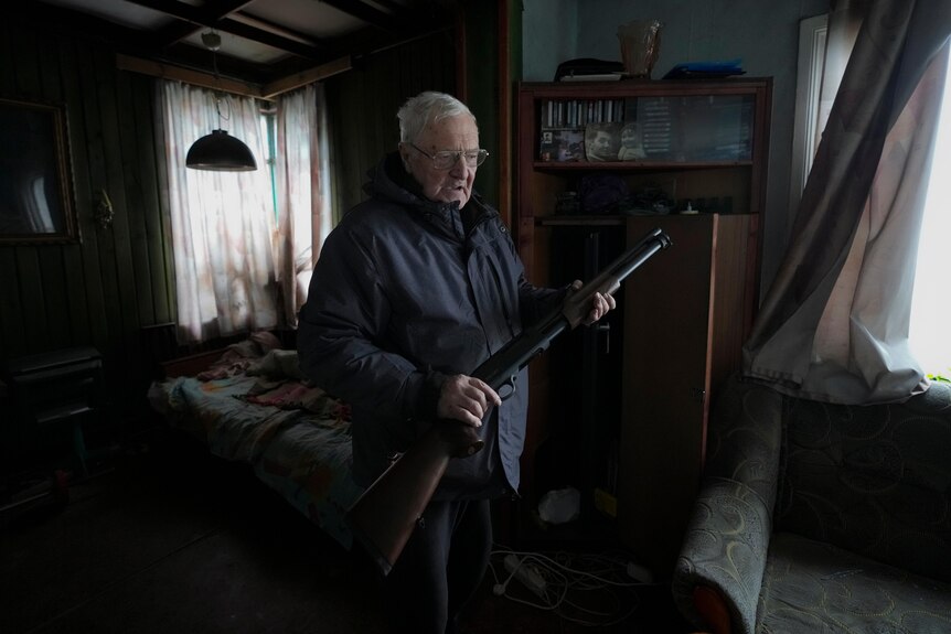 French teacher Pjotr Vyerko, 81, holds a rifle in his house. 