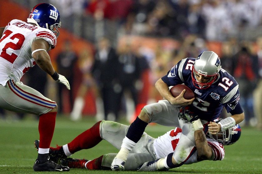 Patriots quarterback Tom Brady is sacked by New York Giants' defensive end Michael Strahan.