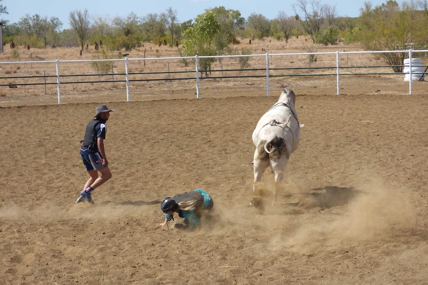 Female on ground as bucking bull jumps away.