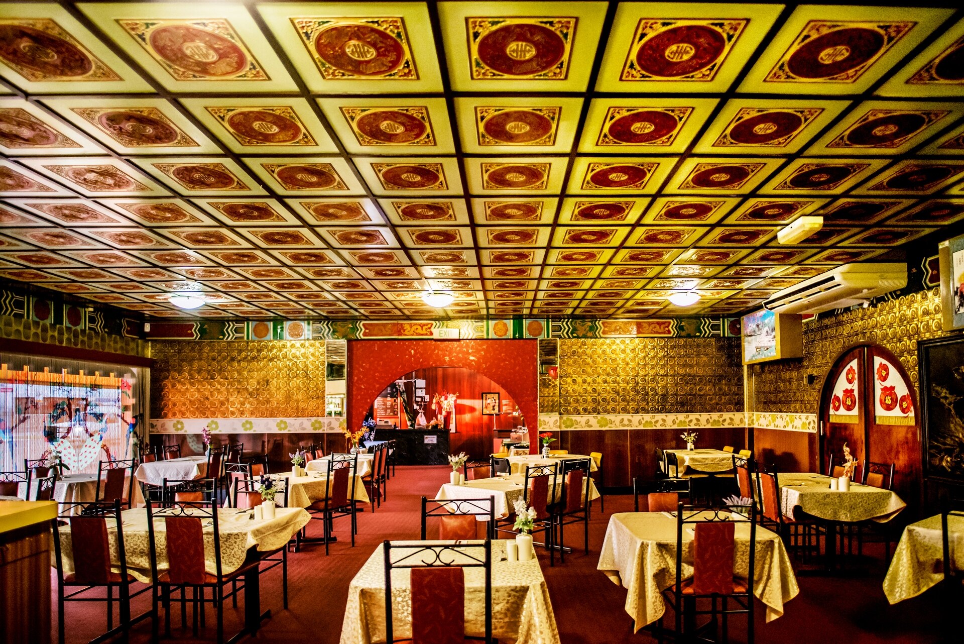 Distinct ceiling tiles with red circles, in what's is clearly a Chinese restaurant