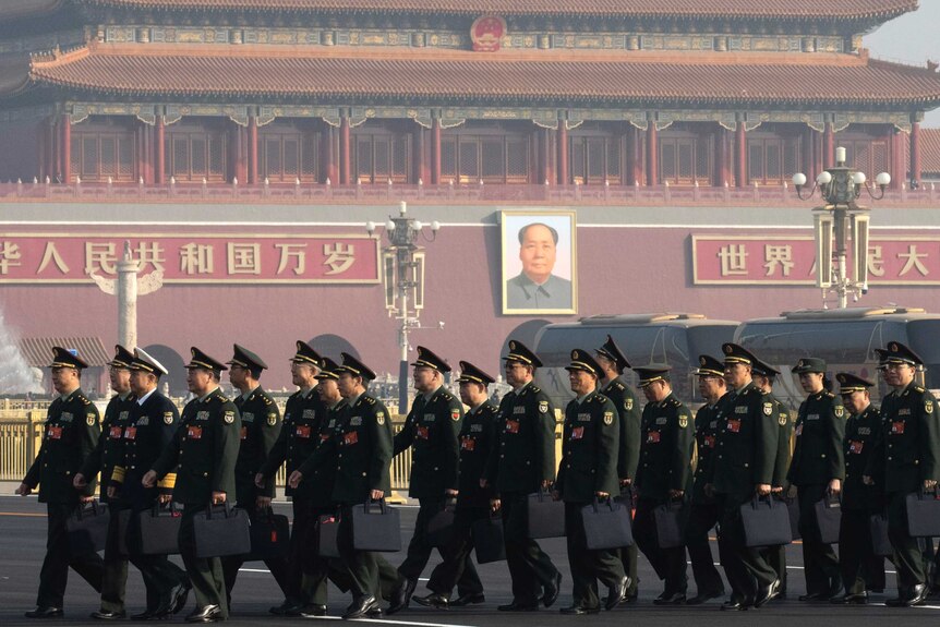 Chinese military delegates arrive, they are in Tiananmen Square, in front of the Forbidden City and Mao's portrait.