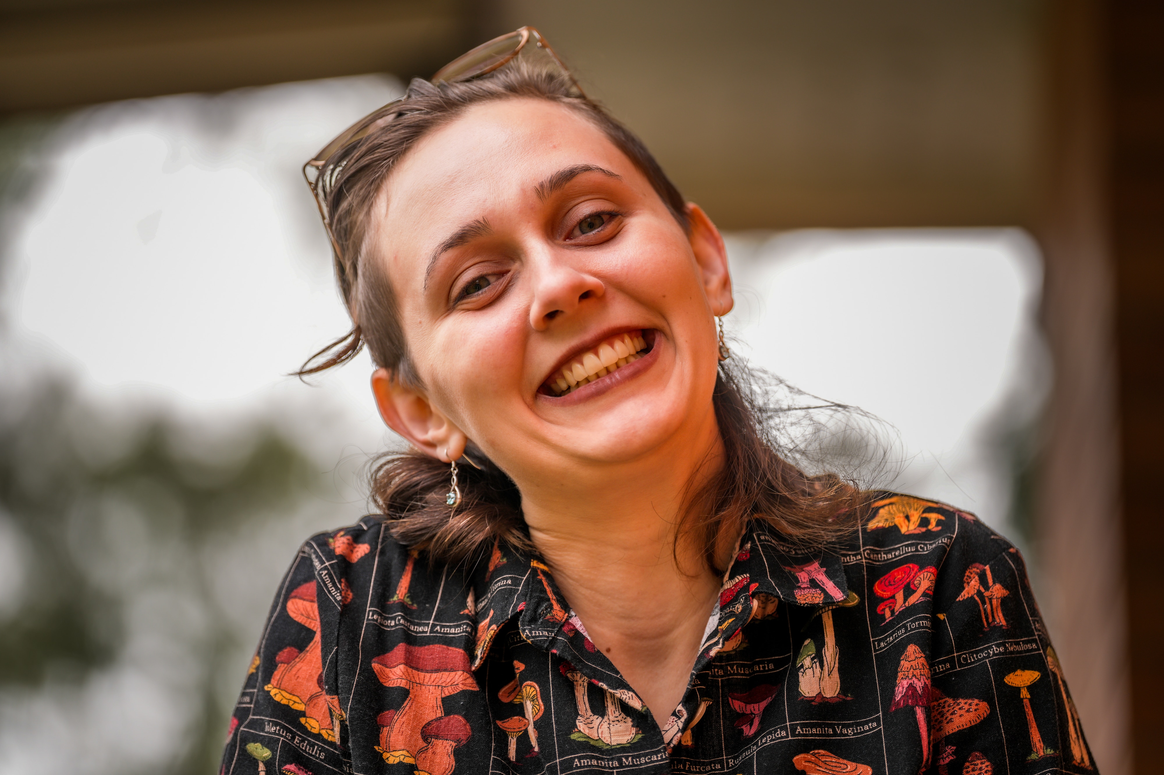 A woman in a colourful shirt smiling