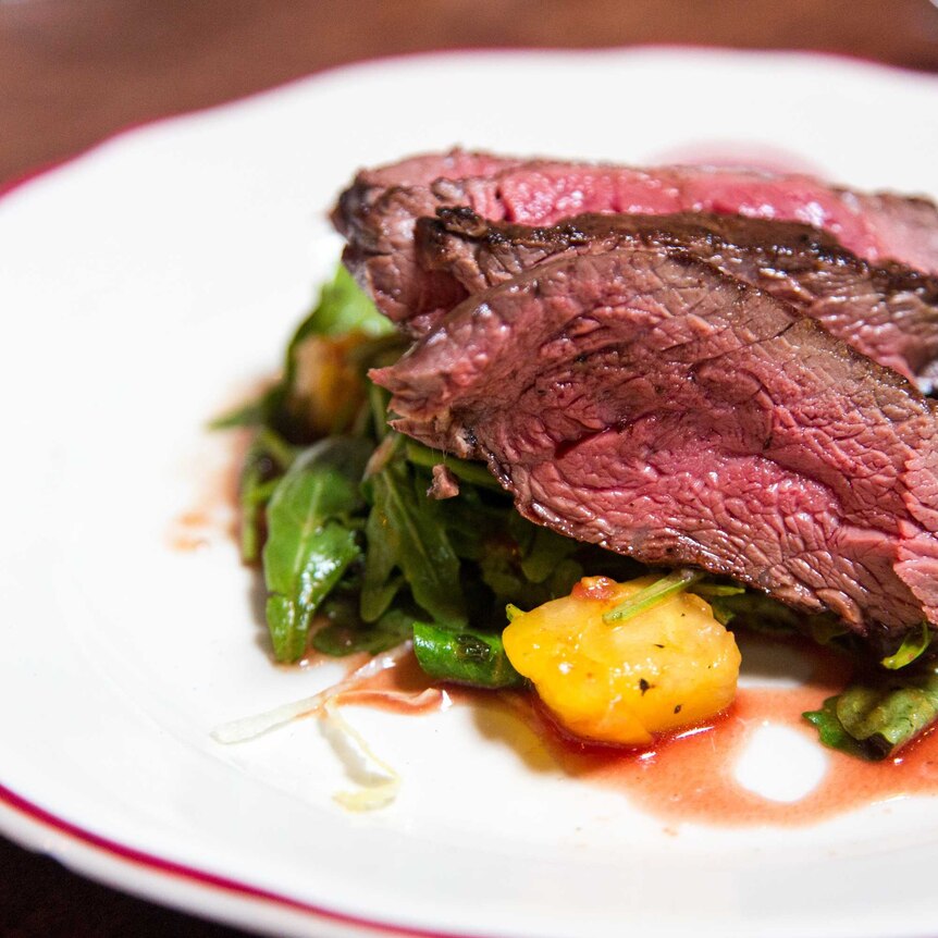 Juicy red meat and greens on a plate